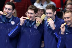 why do olympic swimmers wear coats swimming 2024