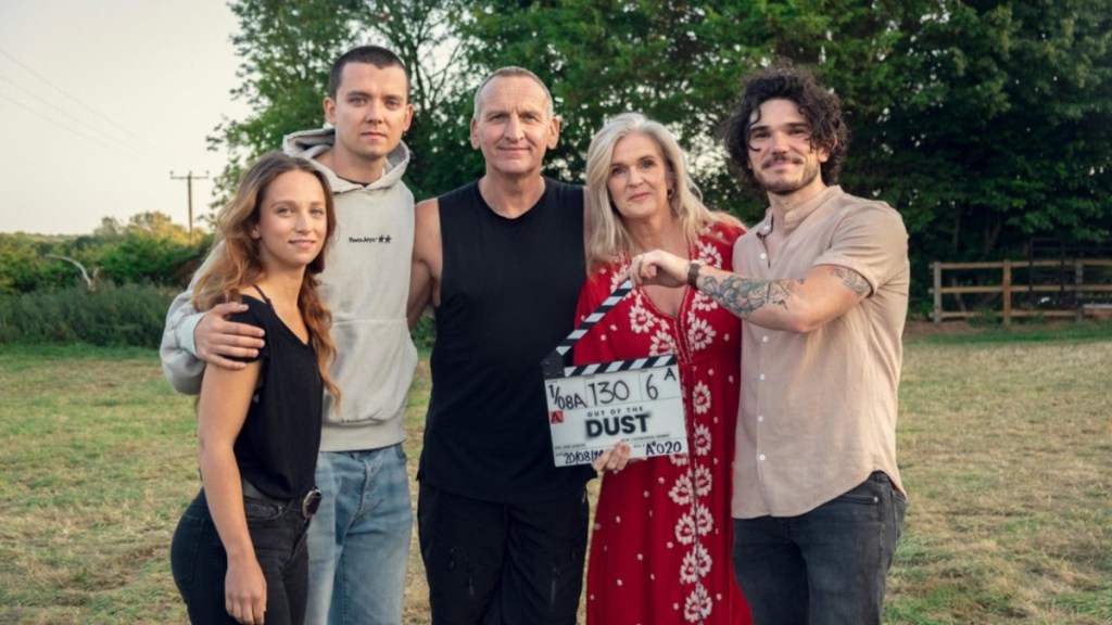 The cast of Out of the Dust stands in a field.