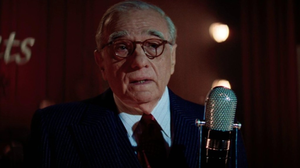 Martin Scorsese speaks in a microphone in Killers of the Flower Moon.