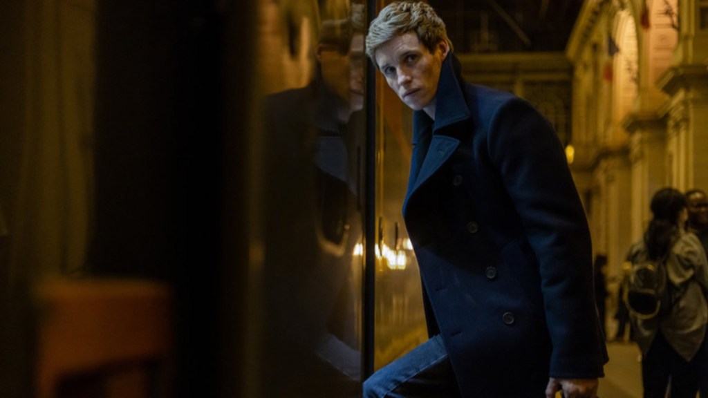 Eddie Redmayne holds a briefcase in The Day of the Jackal.