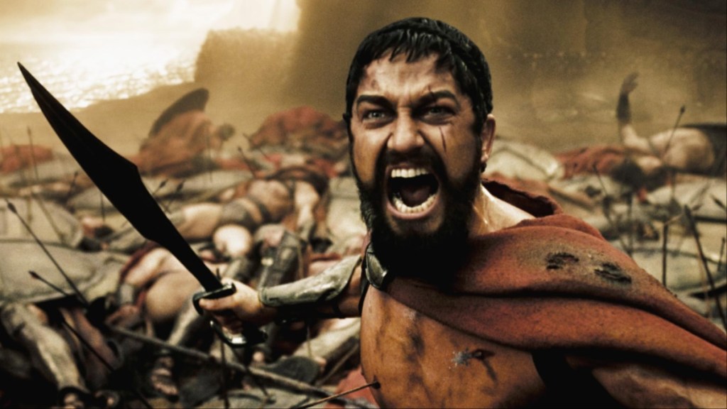 Gerard Butler holds a sword in 300.