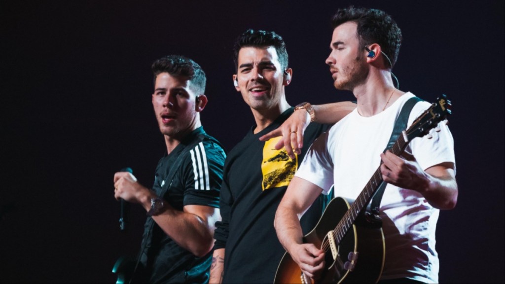 The Jonas Brothers sing onstage in Happiness Continues.