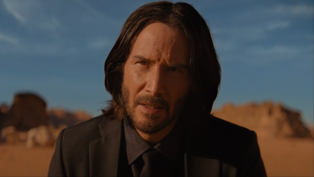 Keanu Reeves sits in the desert in John Wick: Chapter: 4.