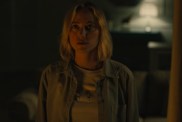 Maika Monroe stares while in the dark.