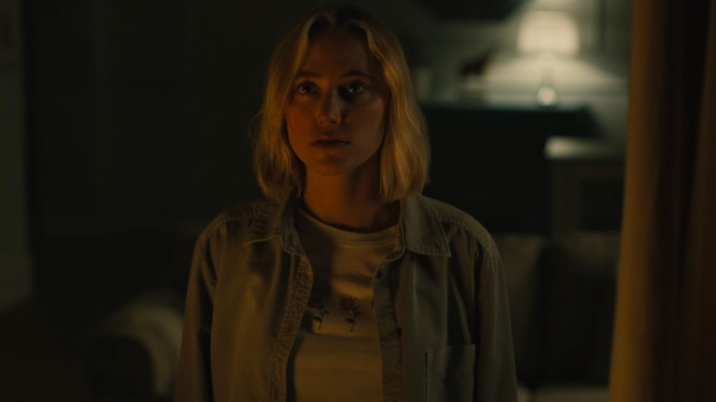 Maika Monroe stares while in the dark.